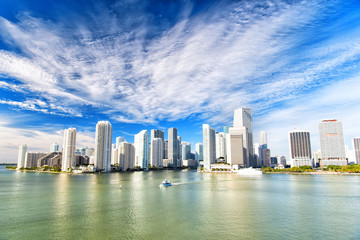 Aerial view of Miami skyscrapers with blue cloudy sky, boat sail