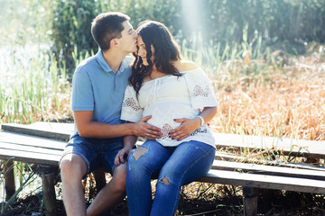 Morning rays illuminate lovely couple sitting on the bench by th