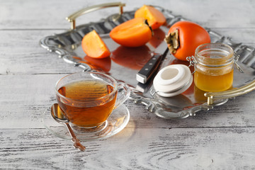 Tea with persimmon on iron tray