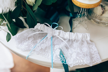 Wedding accessories: Bride's garter and delicate  bow. Closeup