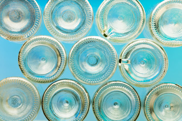 Bottoms of empty glass bottles on blue background