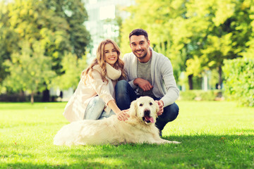 happy couple with labrador dog walking in city