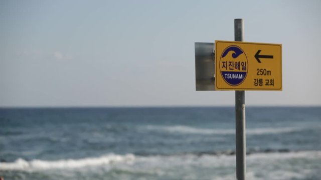 Sign escape route in case of a tsunami alert. The inscription in Korean means "Tsunami" and "Gangneung church"