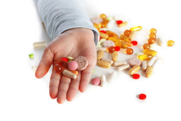 Children hand with gifferent pills