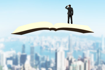 Man standing and gazing on book flying over city