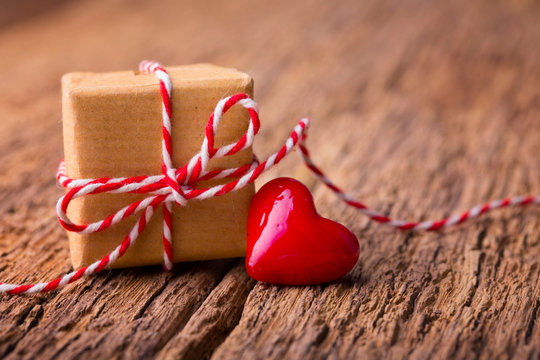 Valentinstag - Geschenk und rotes Herz auf Holz