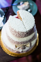 White wedding cake decorated with crystals and glaze bow stands