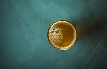Beer, green hops and malt on a stone surface.
