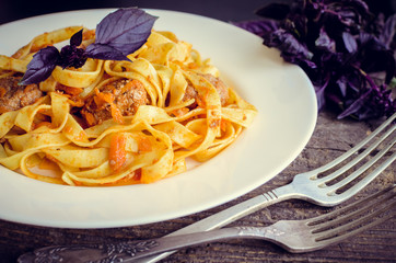 Pasta with meatballs on wooden background
