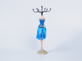 Picture of the bijouterie stay on white background close up. Blue mannequin styled stand for bijouterie.
