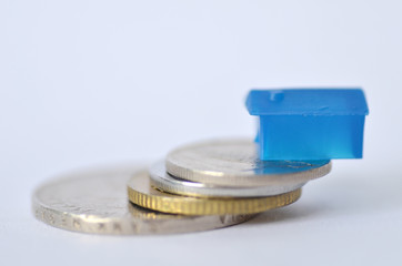 Little plastic house on metal coins