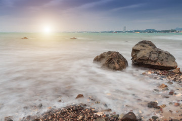 Beautiful sunset in the sea at sattahip beach, Chonburi, Thailand.long expose seascape with rocky, image contain soft focus