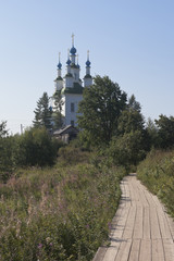 Fototapeta na wymiar Wooden footbridge leading to the Church of Trinity in the town of Totma, Vologda Region, Russia