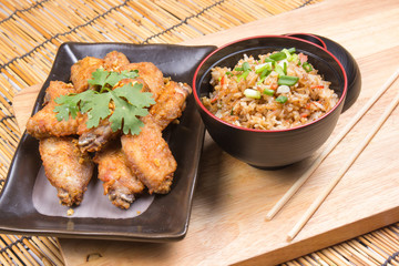 Fried chicken wings served with fry rice