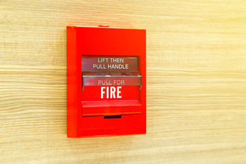 Fire alarm switch isolated on wooden backgound.