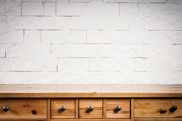 wooden shelf and wall of white bricks