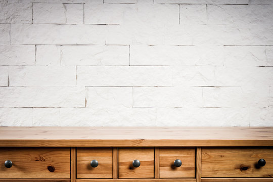 wooden shelf and wall of white bricks