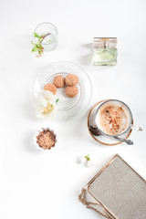 Cup of cappuccino set with cookies, cherry blossoms and perfume