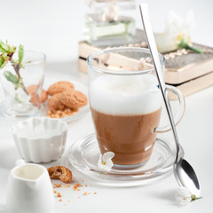 Cup of cappuccino set with cookies, cherry blossoms and perfume
