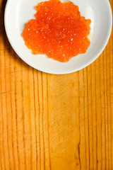 Red caviar with lemon on wooden board white table background. Close up image of delicacy food luxury lifestyle