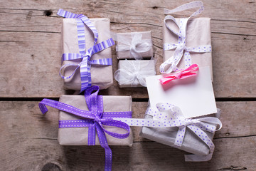 Wrapped  gift boxes with presents  and empty tag on aged wooden