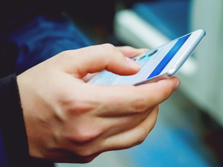 Man holds a smartphone in hand.