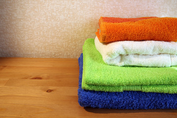 Closeup of four soft colorful towels with some copy space on the left