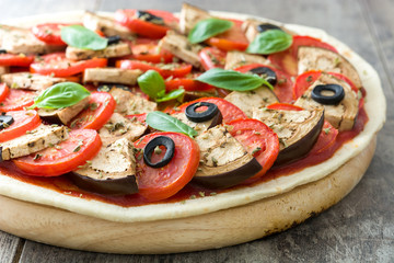 Vegetarian pizza slice with eggplant, tomato, black olives, oregano and basil