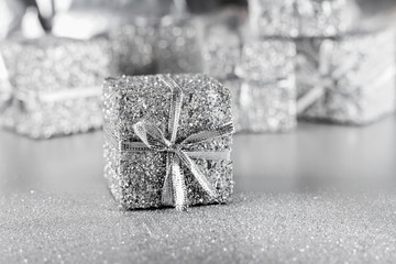 Silver gift with ribbon and bow on a silver background