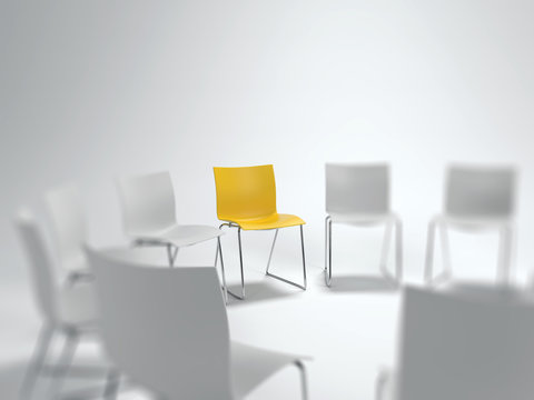 Individual yellow chair in a circle of white ones