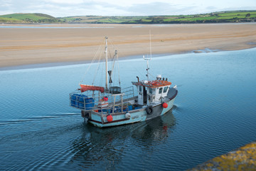 Fototapeta premium Fishing boat arrives in the port of Padstow at the Camel estuary in north Cornwall.