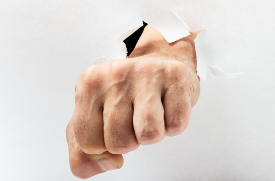 Fist breakthrough  through white paper.