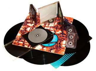 pile old vinyl records in a paper case, tape cassette and cd disk on white background