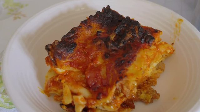 putting  lasagne portions on plates