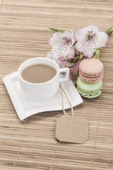 coffee and macaroons on wooden table decorated with flowers