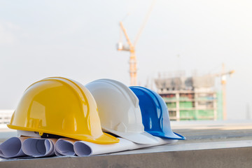 The safety helmet and the blueprint at construction site with cr