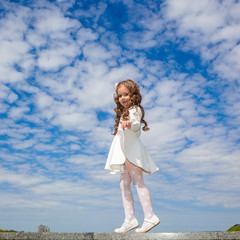Fototapeta premium little girl in the clouds. little girl walks among the clouds. dreamy and fantasy concept