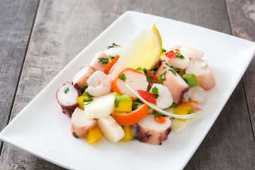 Traditional seafood ceviche from Peru on wooden background

