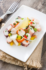 Traditional seafood ceviche from Peru on wooden background
