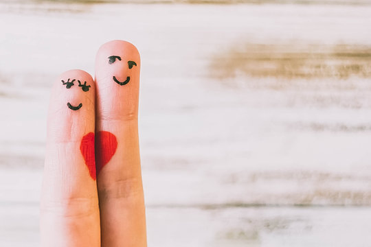 Painted finger smiley on red background, valentine concept.