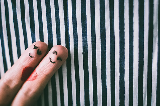 Painted finger smiley on red background, valentine concept.