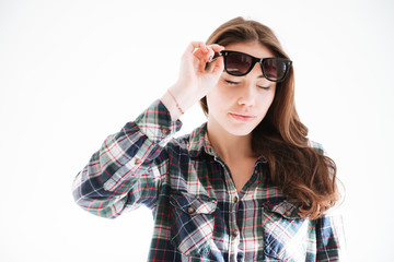 Woman wearing sunglasses standing over white background