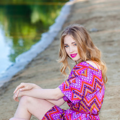 beautiful girl in a pink dress on the beach