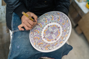 Moroccan potter at work in a pottery shop
