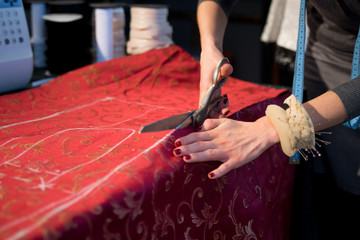 Tailor cutting red cloth large scissors