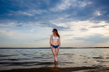 Stylish fashionable blonde girl hipster on sea background. close emotional portraits hipster girl on the evening beach © ruslimonchyk