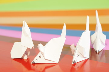 Paper origami mouse and rabbit isolated on the colorful background