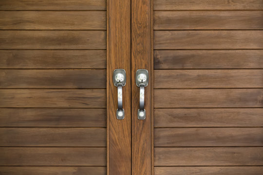 Aluminium door knob on the modern wooden door 
