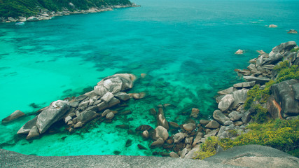  A fantastic turquoise water splashing on rocks sea view and blue sky background in vintage style. 