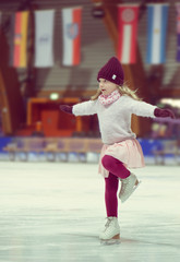 Pretty girl skates in a red cap, warm gloves and sweater